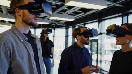 team of employees wearing virtual reality headsets stand in a brightly lit office. VR headsets create immersive experiences. office scene with people immersed in virtual reality. Office environment.