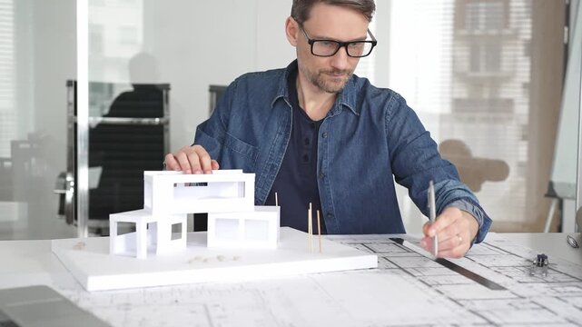 Stressed architect feeling overwhelmed and frustrated, suffering from burnout while working on blueprints for a tight project deadline in a modern office setup