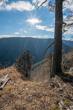 View of sunburst over rugged mountain peaks and dense forest, captured from an elevated vantage point in Koc, Kosice Region, Slovakia.