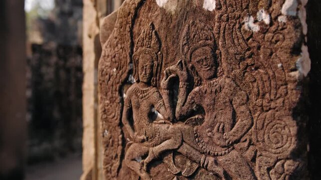 Ancient stone bas relief carving of traditional apsara dancers on a pillar. Detailed historic khmer art at the bayon temple in cambodia. Archeology concept.