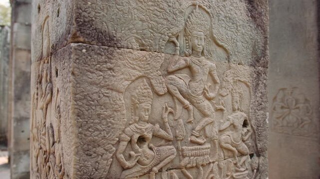 Ancient stone bas relief carving of traditional apsara dancers on a pillar. Detailed historic khmer art at the bayon temple in cambodia. Archeology concept.