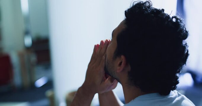 Stress, praying and man in home with anxiety, mental health or fear with spiritual forgiveness. Religion, prayer and male person in bedroom with phobia, ptsd or regret with begging for compassion.