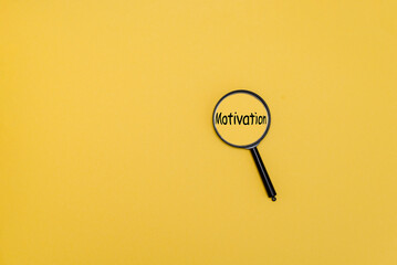A magnifying glass focuses on the word 'Motivation' against a bright yellow background. The scene emphasizes themes of inspiration and personal growth.