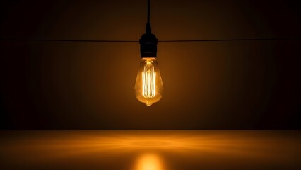 Warm glowing light bulb hanging in dark room with string lights