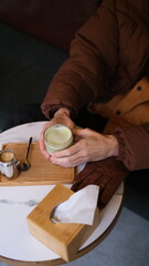Male hands holding matcha latte top down view