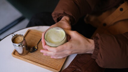 Male hands holding matcha latte top down view