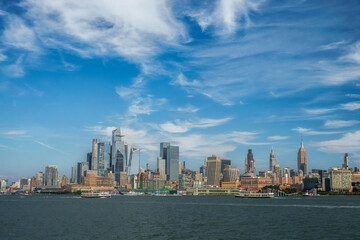 Fototapeta premium New York City skyline with Hudson Yards skyscrapers and passing cruise ship. Manhattan Midtown West cityscape from Hoboken River Park piers