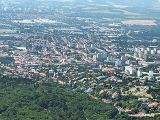 Sixteenth image in a series presenting a panoramic view of the city of P&eacute;cs, Hungary, captured from the observation deck of the TV tower. Elevated perspective highlighting rooftops, urban landscape, g