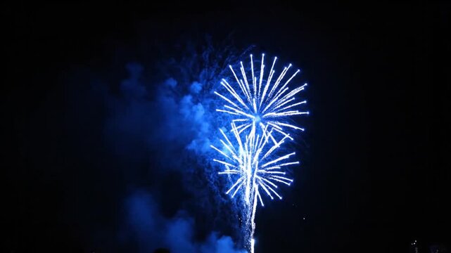 Dramatic blue fireworks display against a black sky background