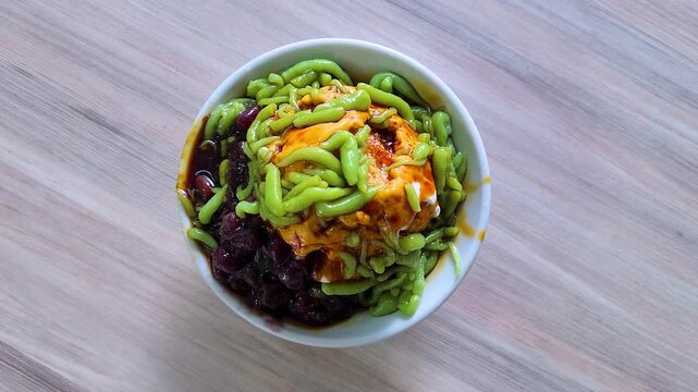 Cendol is a Malaysian dessert made of shaved ice, coconut milk, green pandan jelly noodles, and sweet dark brown sugar syrup (Melaka Sugar). Optional toppings include red beans or sweet corn for extra