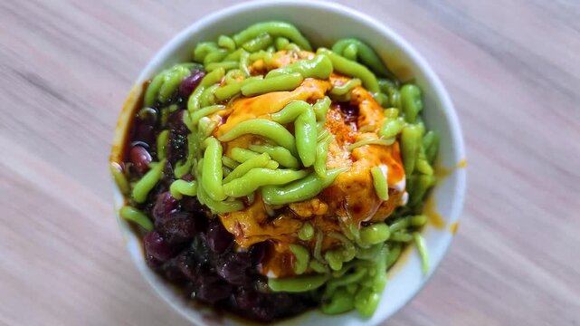 Cendol is a Malaysian dessert made of shaved ice, coconut milk, green pandan jelly noodles, and sweet dark brown sugar syrup (Melaka Sugar). Optional toppings include red beans or sweet corn for extra