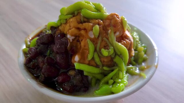 Cendol is a Malaysian dessert made of shaved ice, coconut milk, green pandan jelly noodles, and sweet dark brown sugar syrup (Melaka Sugar). Optional toppings include red beans or sweet corn for extra