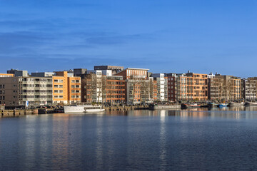 Modern residential architecture on Java Island. Colorful apartment buildings along the waterfront on a sunny day. Amsterdam Netherlands, 28 december 2025