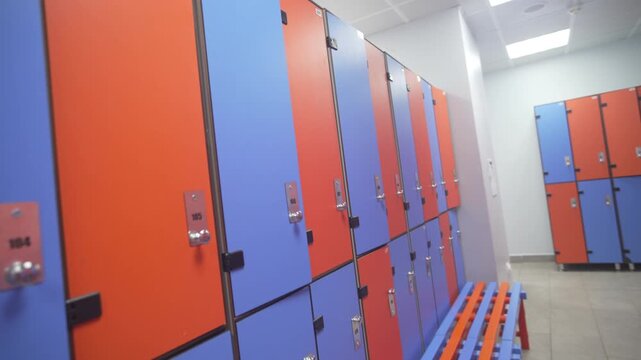 Benches aligned with locker colors enhance usability and visual harmony in pool changing area. Space appears organized ergonomic friendly