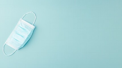 angled medical mask on pastel blue surface, single disposable mask photographed with generous negative space for copy, evokes commuter safety and workplace hygiene reminder, suitable for lifestyle