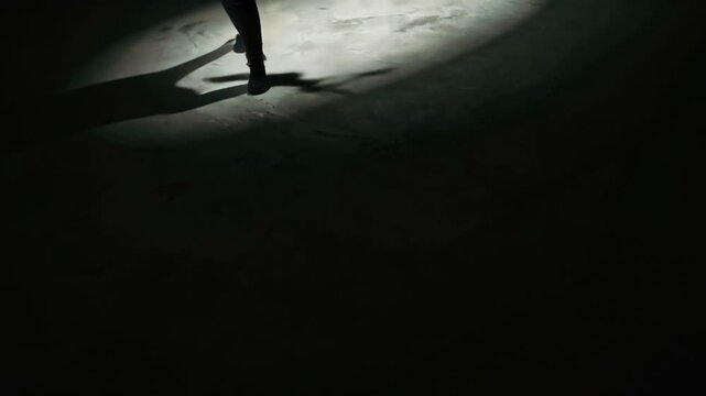 Minimal cinematic scene, concrete floor single white spotlight, abstract human shadow moving edge of light, slow organic motion, high contrast lighting, mysterious atmosphere, psychological concept 4k