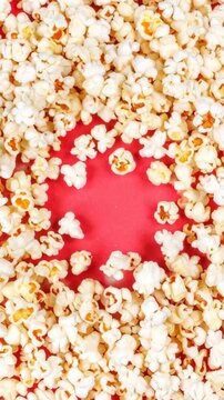 Abundance of delicious fresh popcorn against bright red background, offering a tempting close-up for snacking and entertainment concepts