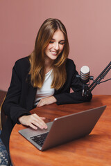 Podcast interview with girl at home using laptop and microphone during evening hours