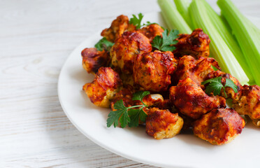 Fototapeta premium Buffalo Cauliflower in Batter with Celery on a White Plate