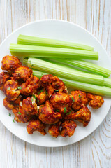 Buffalo Cauliflower in Batter with Celery on a White Plate