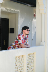 man in Hawaiian shirt standing in the hallway of the hotel in tropical country in summer day