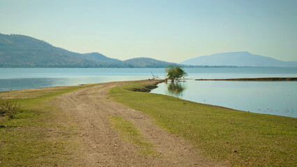 Dirt road leading to the lake with mountains in the background.