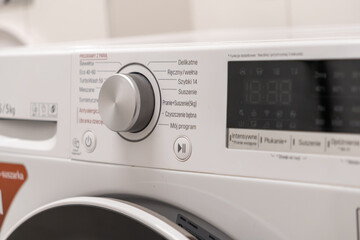 Modern washing machine control panel with program dial and digital display, highlighting advanced laundry settings for efficient home care and household chores