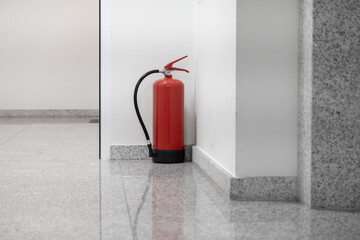 Red fire extinguisher securely positioned in a bright, modern building corridor, symbolizing crucial safety, emergency readiness, and fire protection measures