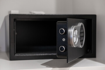 Empty open black electronic safe with a digital keypad and silver handle, representing secure storage for valuables in home or hotel environments