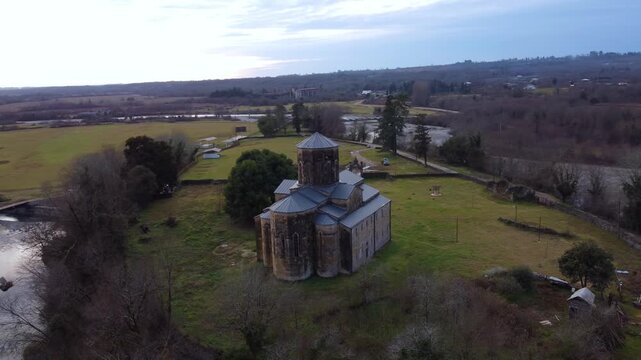 MOKVA, Abkhazia - 4.01.2025: Mokva Cathedral of the Assumption of the Blessed Virgin Mary, aerial view. Christianity. Holy sites. Ancient church built in the 10th century. Christian shrine. Dron. 4К
