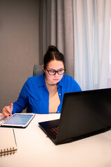 Working remotely from cozy home interior. Woman enjoys location-independent work with laptop in comfortable home settings. Freedom and flexibility of working from anywhere. Modern technology concept