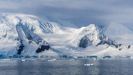 Glacier in Antarctica Wilhelmina Bay Beautiful Frozen Landscape. Wide Snow on Mountain Range. View from Cruise Ship Climate Change Melting Ice Caps © And They Travel