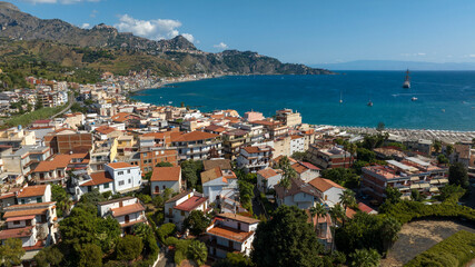Obraz premium Aerial view of Giardini Naxos, a town in the province of Messina, Sicily, Italy. It overlooks a gulf of the Mediterranean Sea. It is a popular tourist destination and a cruise ship stop.