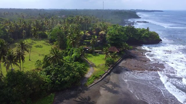The Hindu temple of Pura Dalem from a bird's-eye view. The temple is located on Pantai Bonian Beach, which has volcanic black sand, in the Indian Ocean on the island of Bali. Dron. 4К