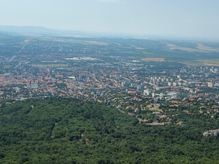 Obraz premium Twentieth image in a series capturing a panoramic view of the city of Pécs, Hungary, from the observation deck of the TV tower. Elevated perspective highlighting rooftops, urban landscape, greenery, a