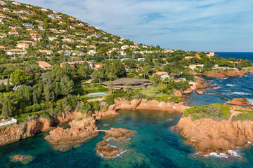 Aerial view of the village of Antheor, with the iconic red rocks of the Esterel Massif at sunset, French Riviera