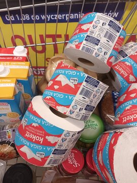 Shopping cart filled with toilet paper rolls and groceries, ready for home