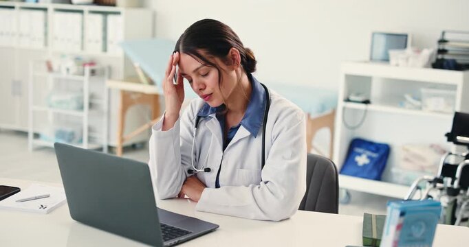 Doctor, woman and headache with laptop in office with stress, pain and tired at hospital. Person, medical professional and frustrated with migraine, burnout or vertigo with pc with clinic admin