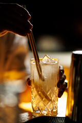 Bartender stirring cocktail with chopsticks