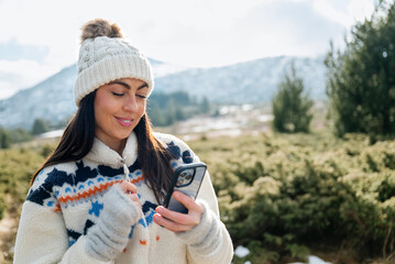 Beautiful  Woman using mobile phone in the Winter Mountain 