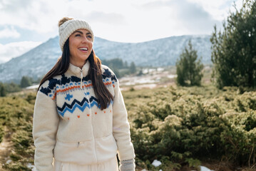 Beautiful  smiling young tourist woman standing in the winter mountain 