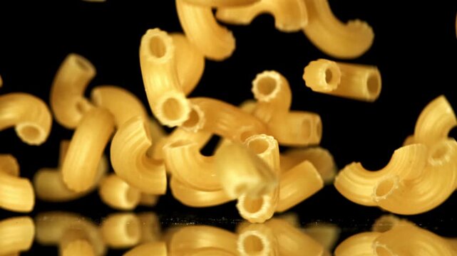 Super slow motion dry macaroni pasta . Filmed on a high-speed camera at 1000 fps. High quality FullHD footage