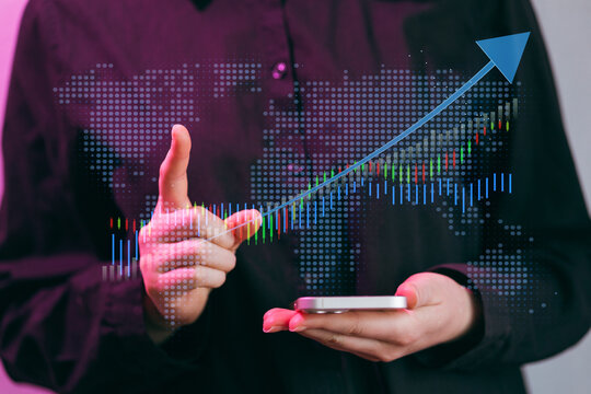 Businessperson shows growth trend on mobile device with graph and world map background in modern office setting - Powered by Adobe
