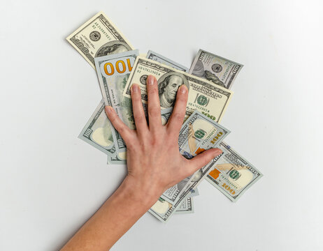 Woman's hand on pile of hundred dollar bills. Money control, savings, financial pressure, planning.