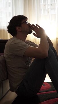 man sitting on bedroom floor and praying for divine help, asking for divine guidance during a crisis