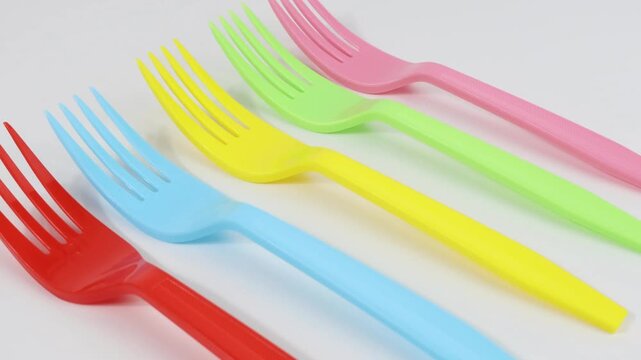 Colorful plastic forks with white background, copy space left side position.