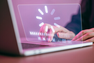 Busy person working on laptop with loading screen in bright colors during late hours in an indoors workspace