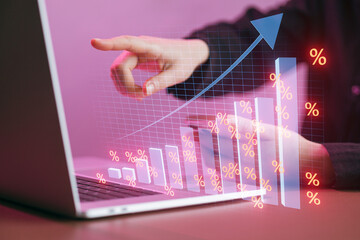 Growth trends shown on computer screen with hand pointing towards data representation at office setting