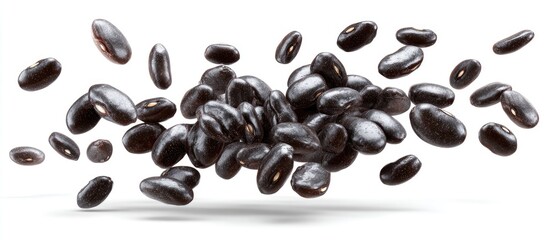 Obraz premium Close-up of black beans, some in mid-air and some in pile, with a soft shadow beneath on white