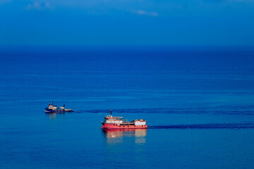 Two ships on calm blue sea with clear horizon and minimal seascape